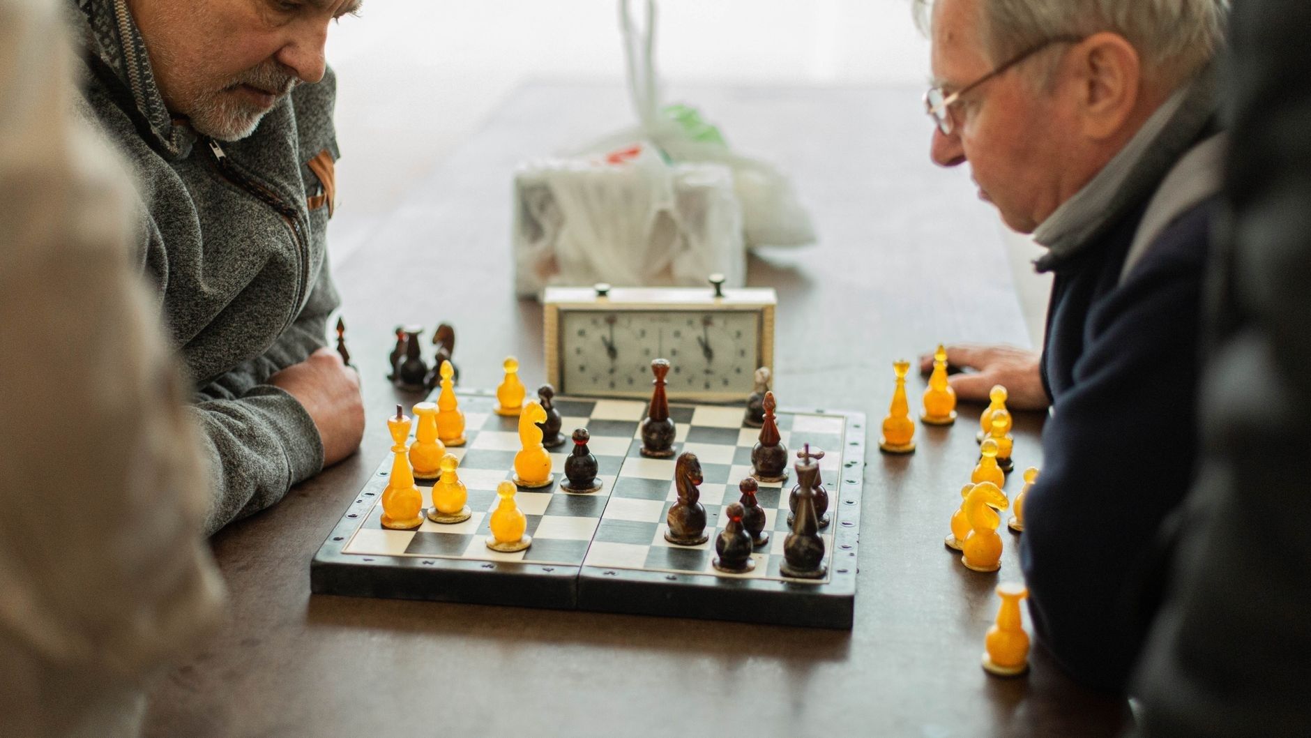Två personer spelar schack vid ett bräde under en koncentrerad match